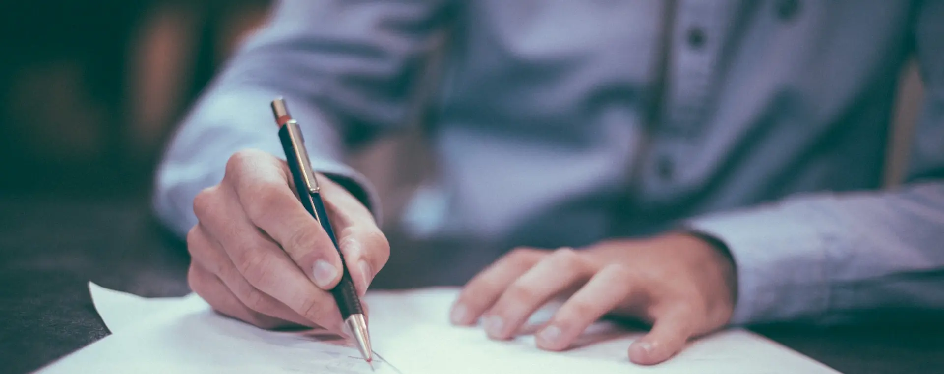 man writing on paper